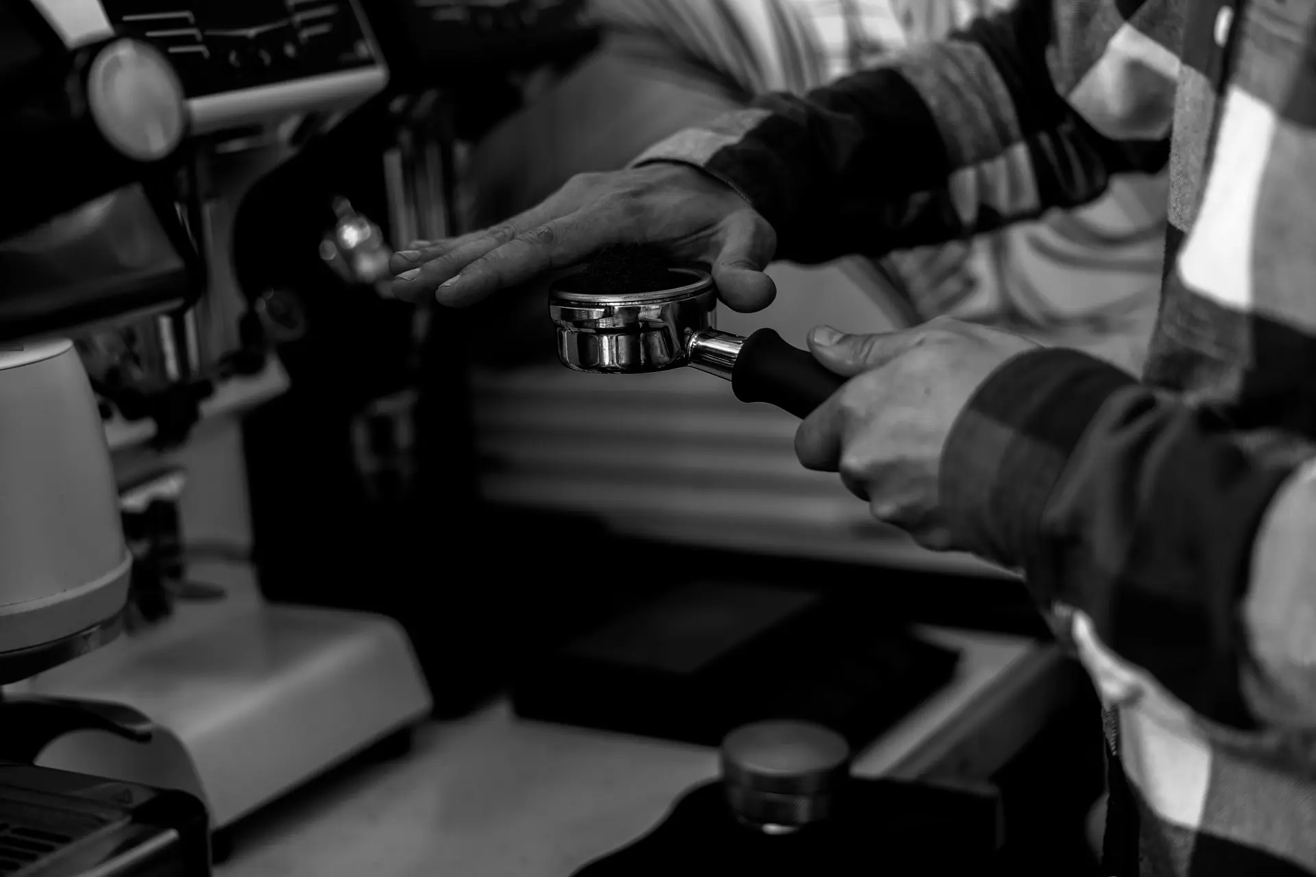 Barista verteilt Kaffeemehl in Siebträger